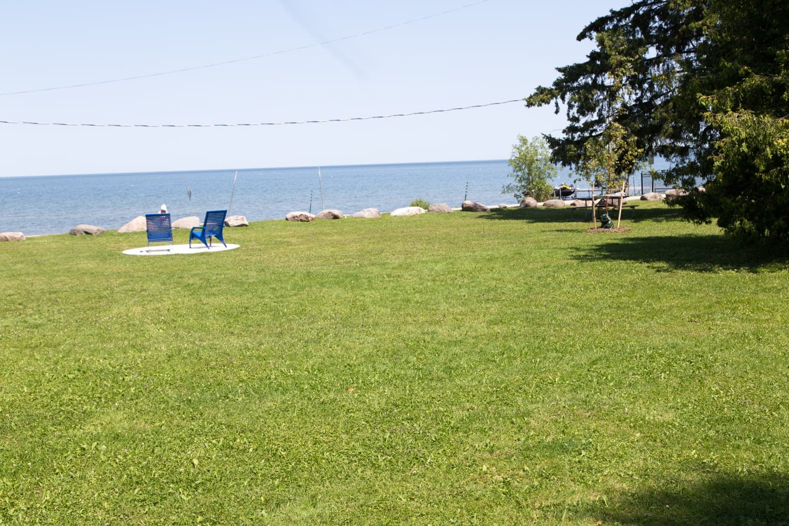 Two blue chairs on a concrete pad facing out over the water at Franklin Beach